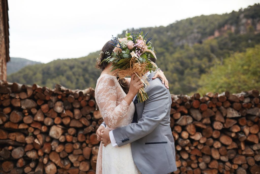 foto de boda cubriendo un beso con el ramo
