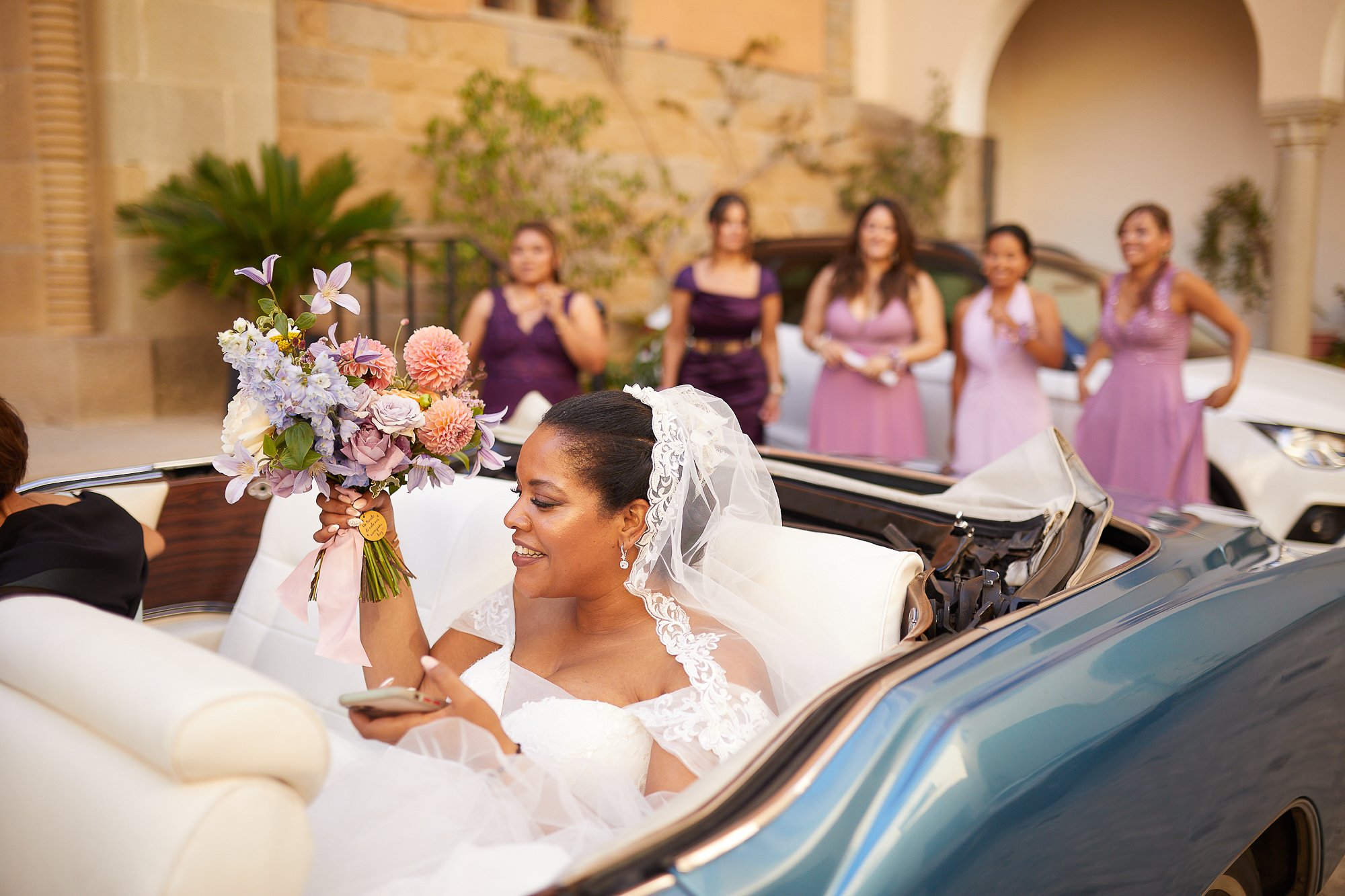 damas de honor despidiendo a la novia en el coche