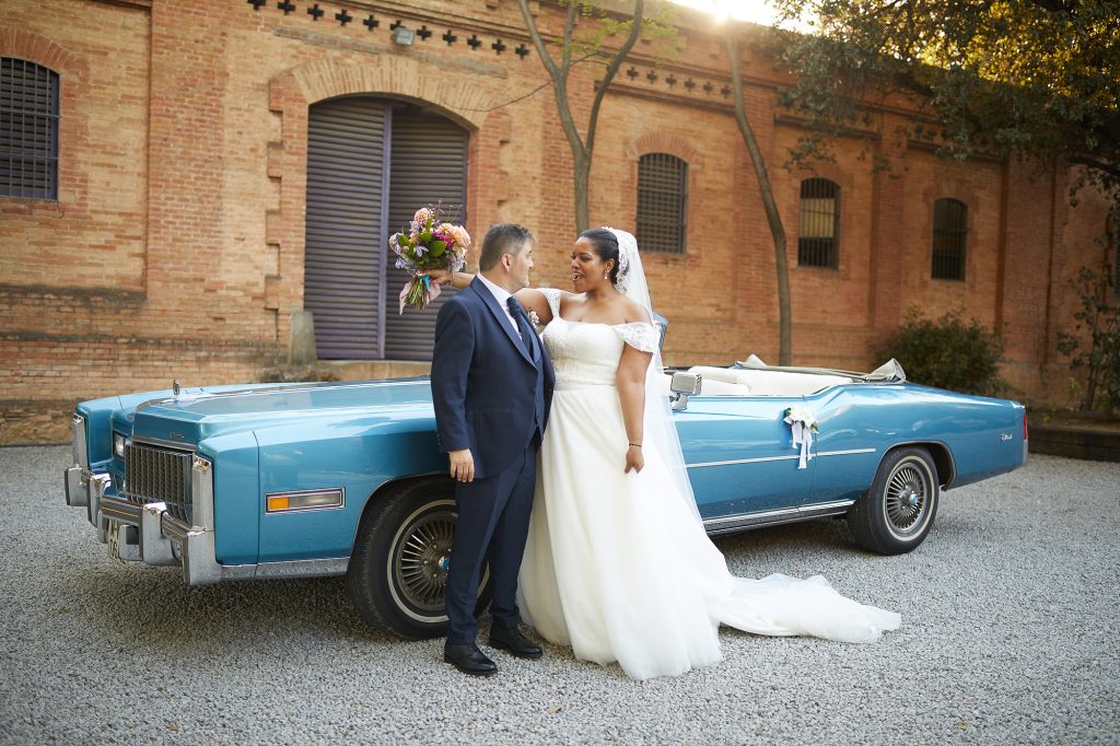 novios posando para la foto delante del coche