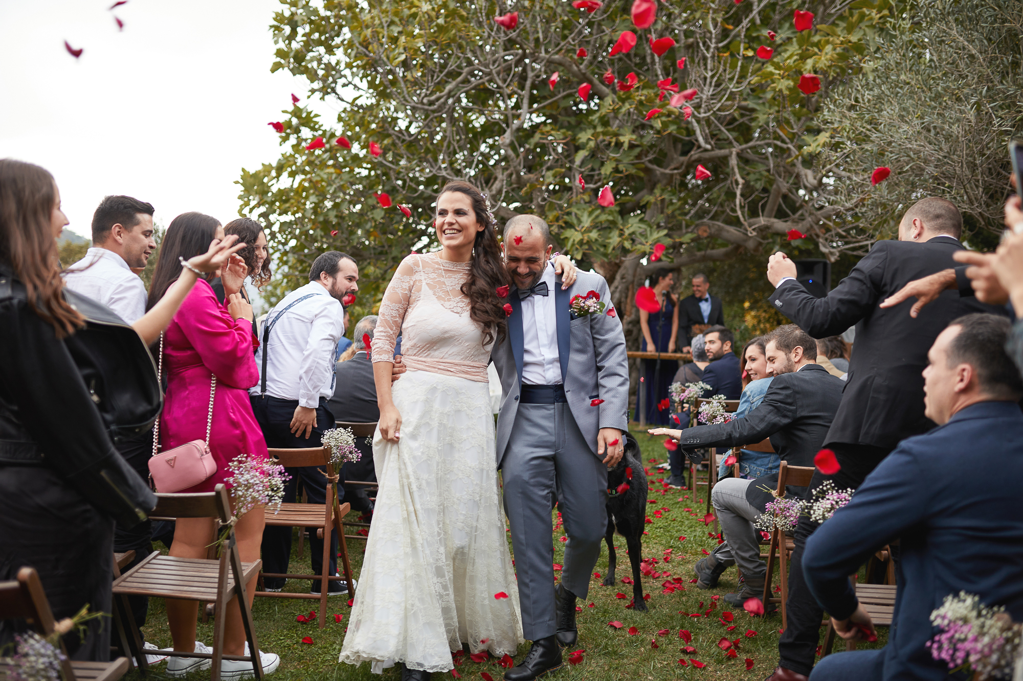 invitados lanzando pétalos de rosas a los novios