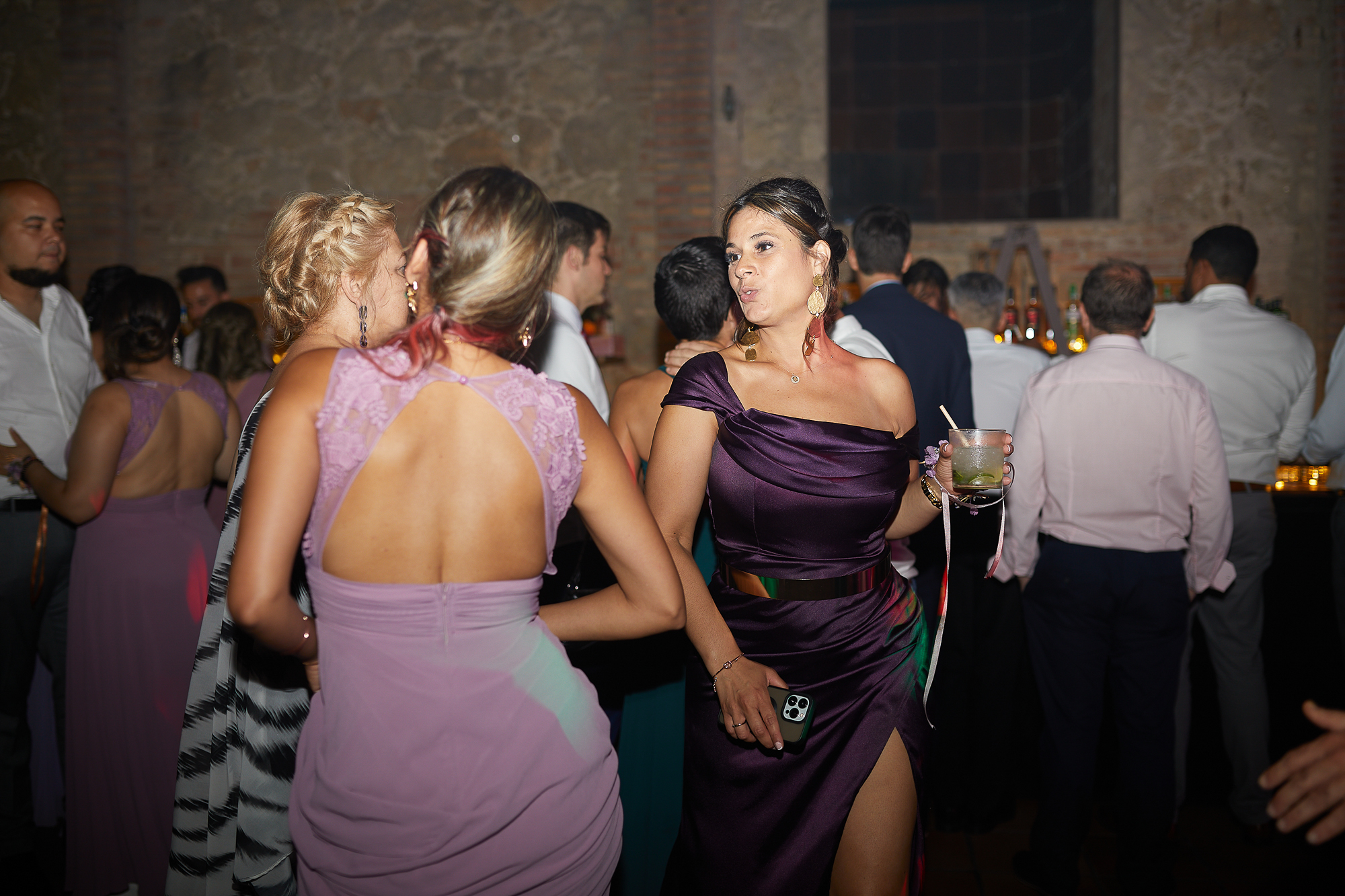 invitadas bailando y bebiendo una copa en la fiesta de la boda