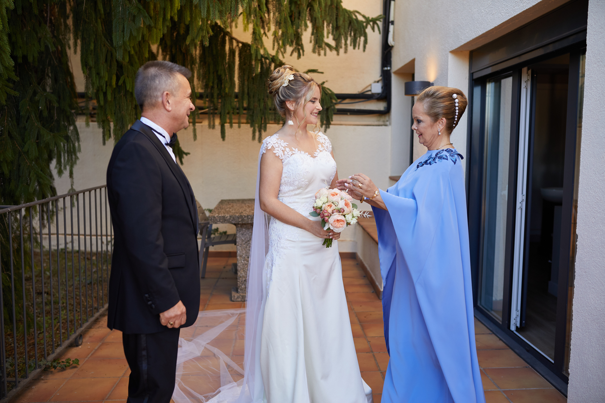 la novia con sus padres en el patio