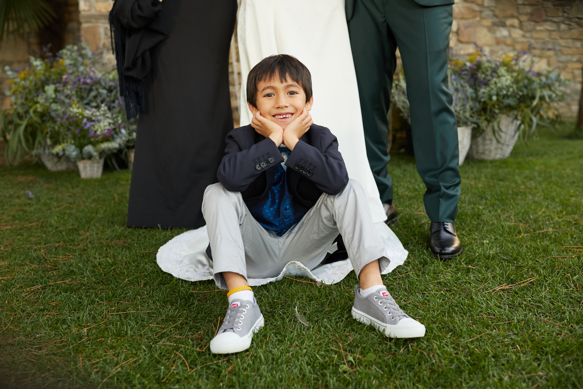 niño sentado en el vestido de la novia