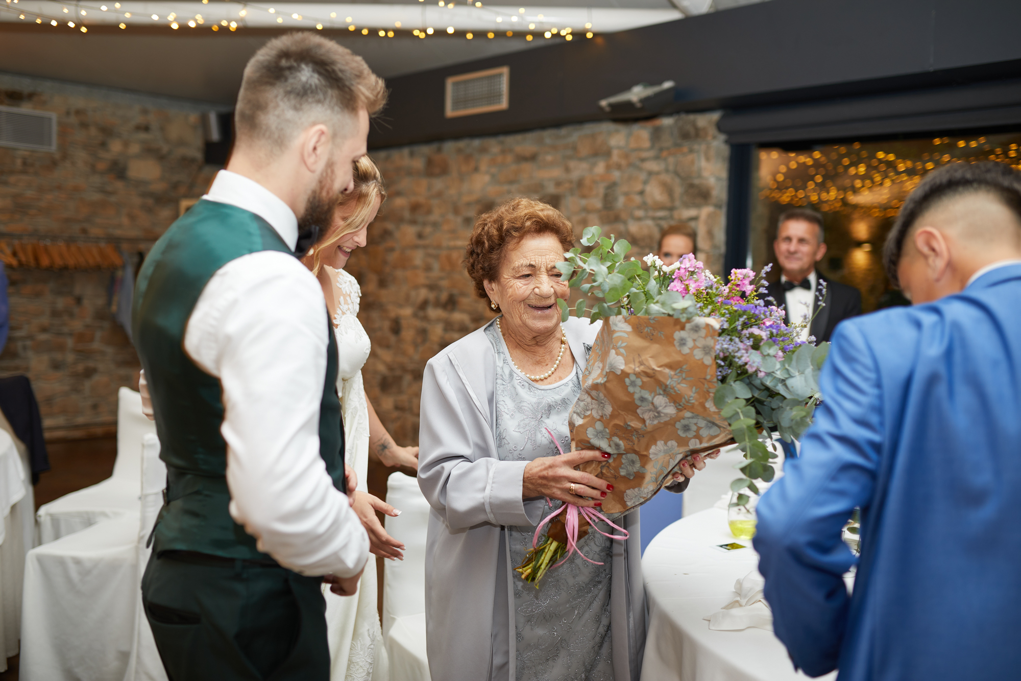 novios le dan un ramo de flores para la abuela